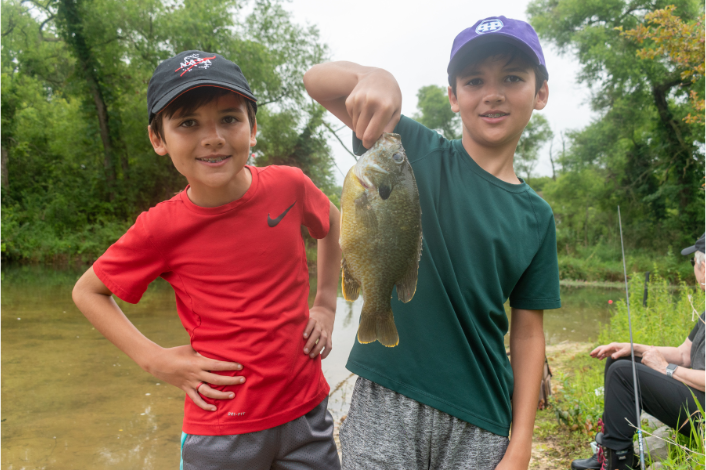 Two Boys with a fish by a stream