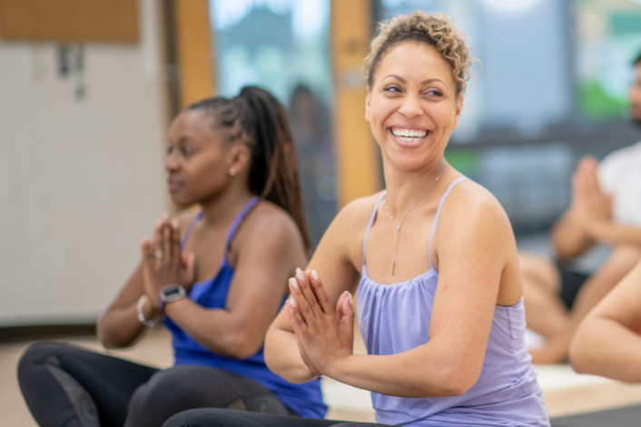 Two women seated practicing gentle yoga
