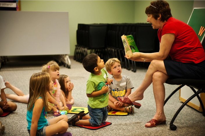 Adult educator reading to preschool kids