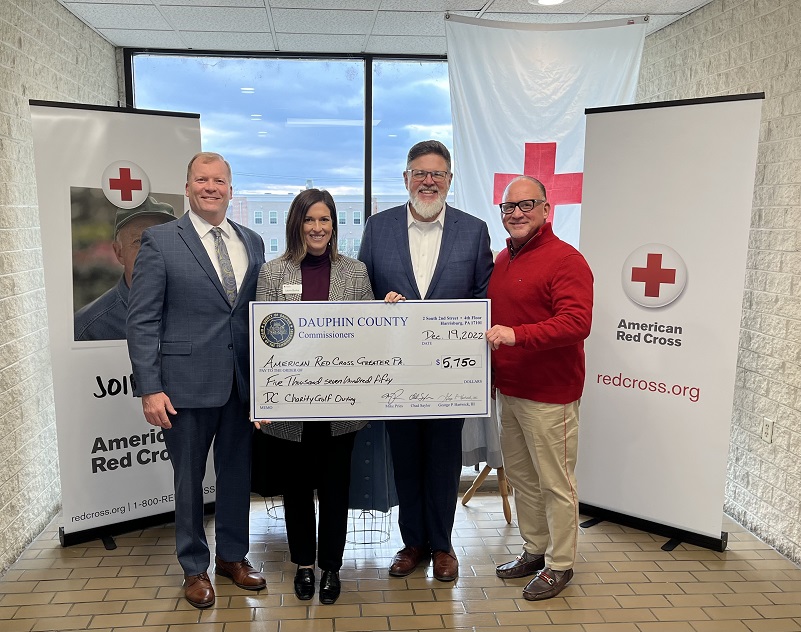 The commissioners deliver a check to American Red Cross.