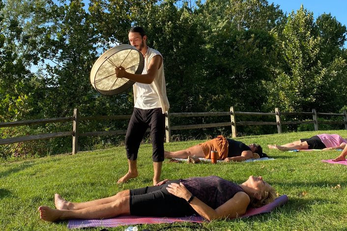 People on yoga mats in the grass enjoying sound meditation