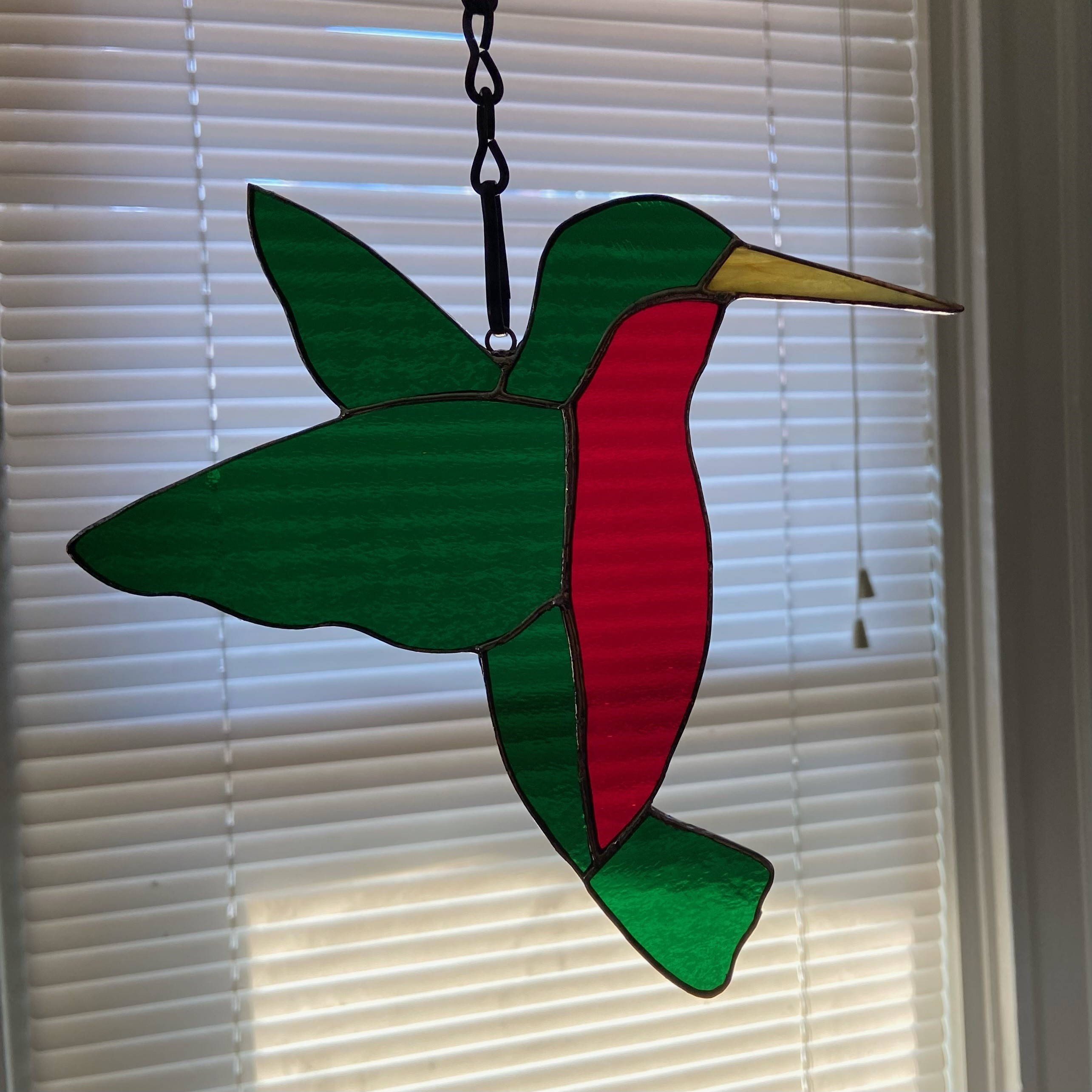 stained glass hummingbird hanging in window