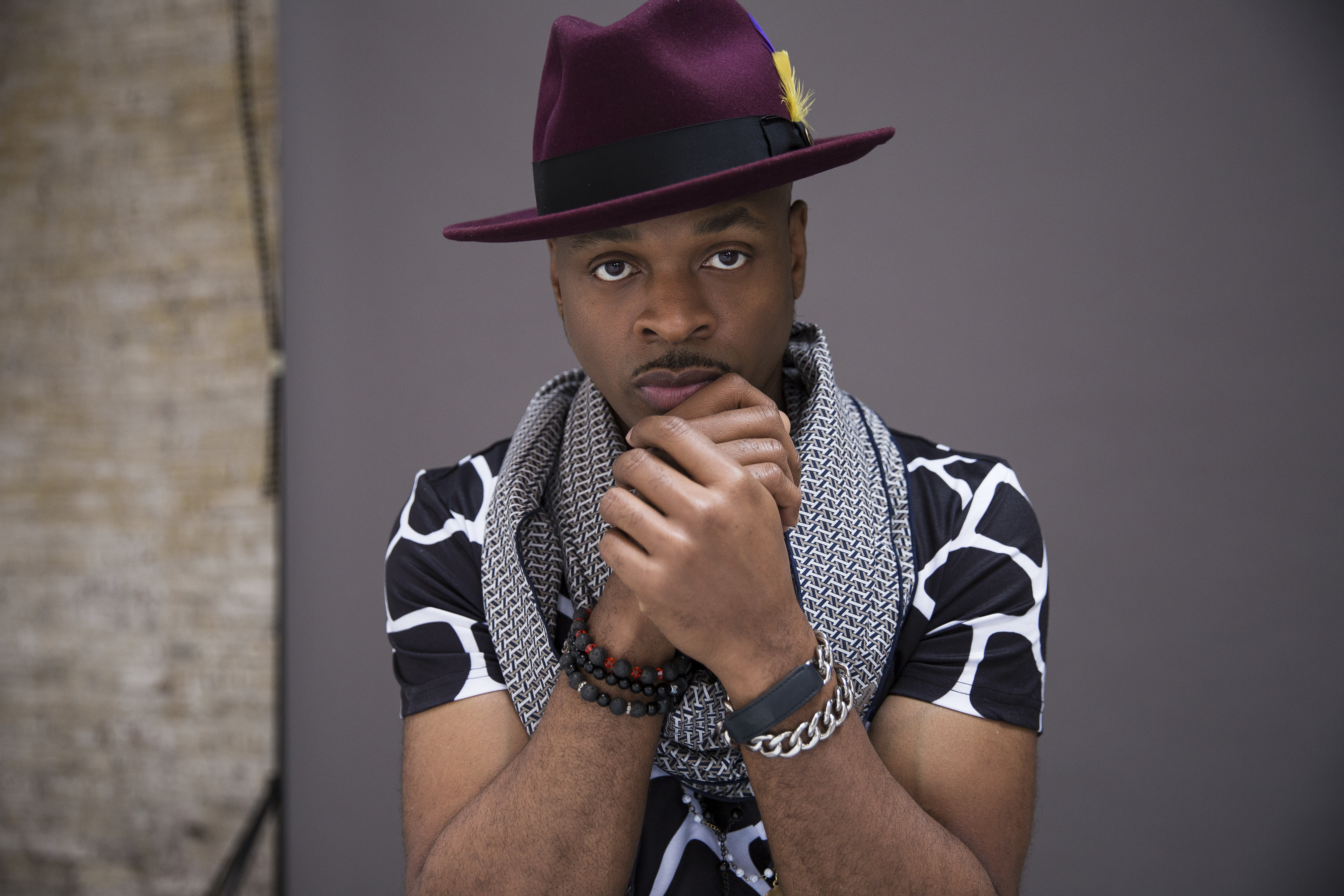 Image of entertainer Stokley in a black and white shirt with a purple hat