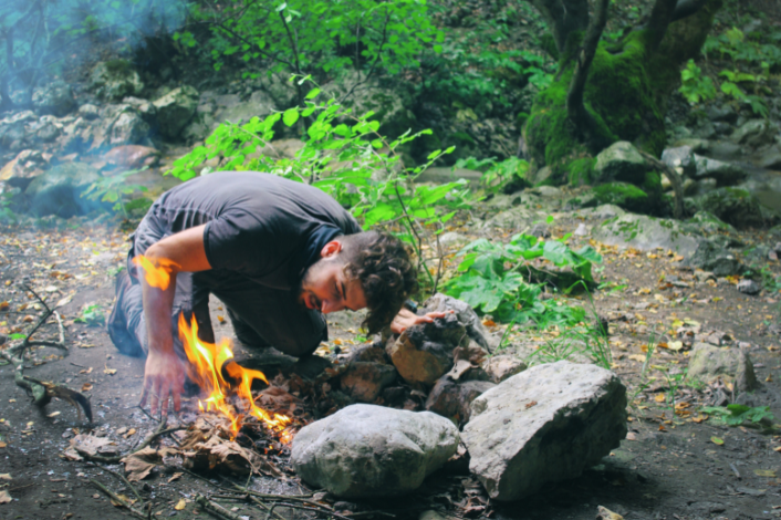 A man starting a fire outside