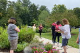 Group of people admiring trees, plants and flowers outdoors