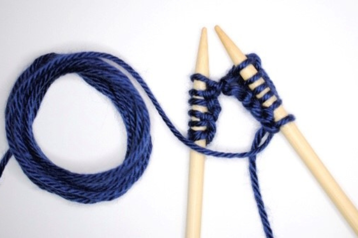 Knitting needles and dark blue yarn