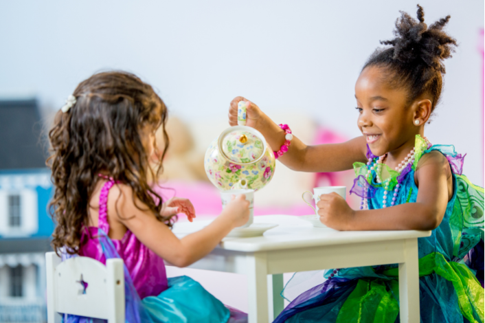 Two young girls having a tea party