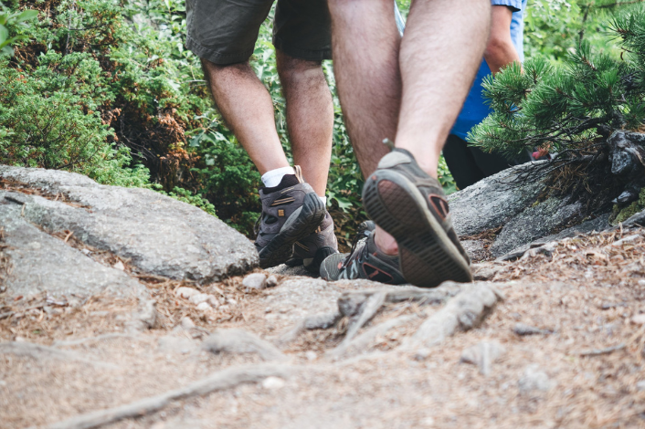 Feet in boots walking on rocks outside