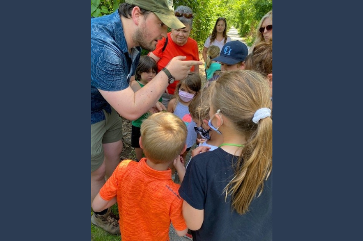 Adult speaking to kids outside in a park