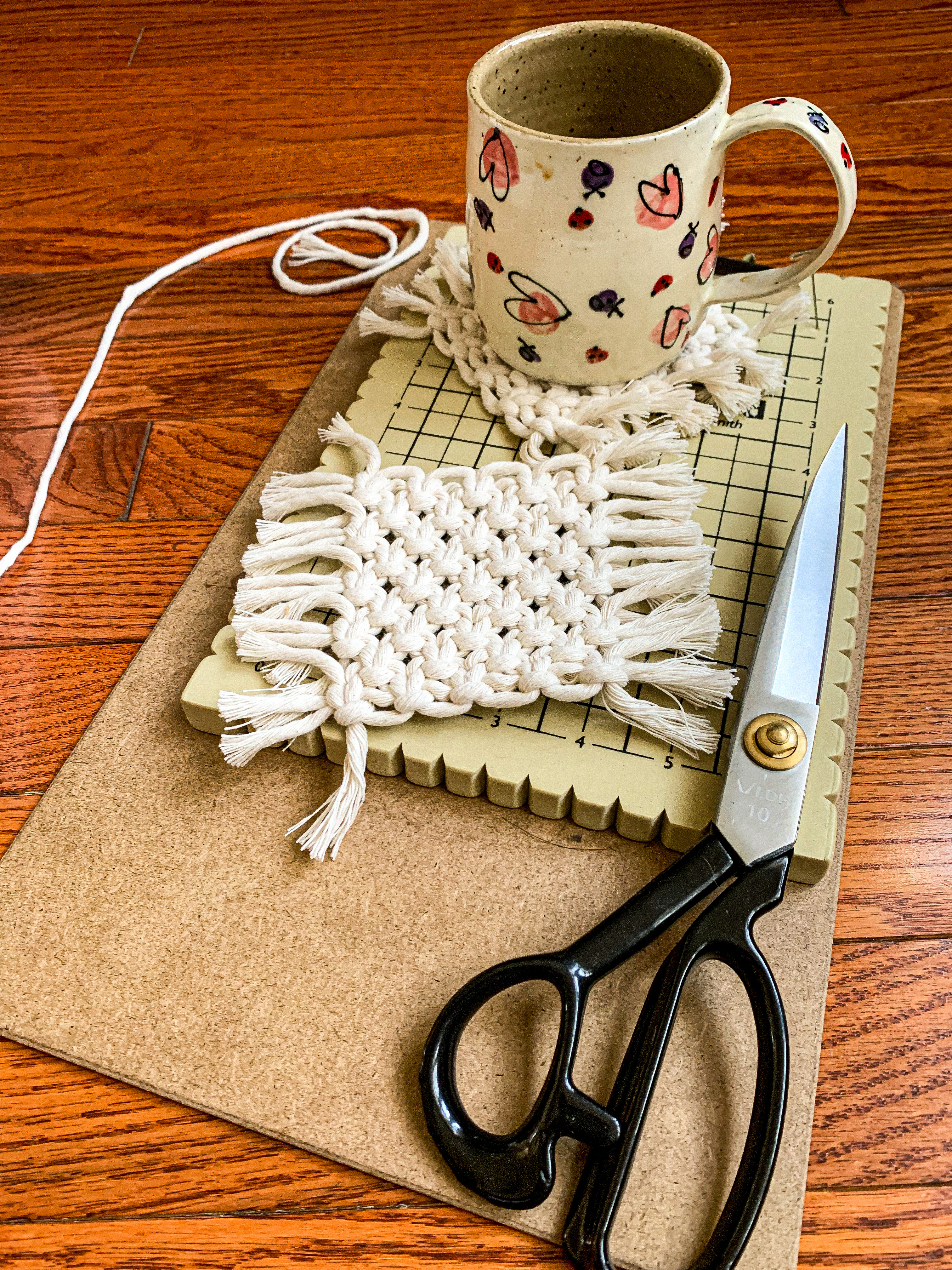 macrame coaster under a mug on a table with scissors