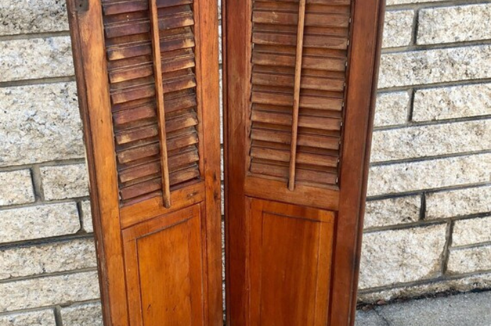 Barn shutters against a white stone wall